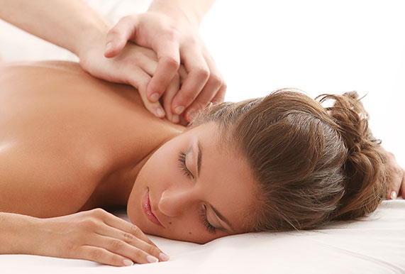 o femeie care se bucură de un masaj relaxant pe spate, la nivelul coloanei vertebrale, cu mâinile unui specialist